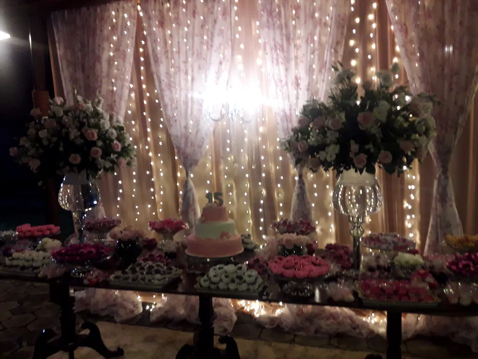 Fundo de cerimônia com cortina de luzes, arranjos de flores brancas e velas